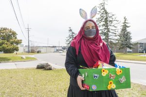 Woman with bunny ears holding box